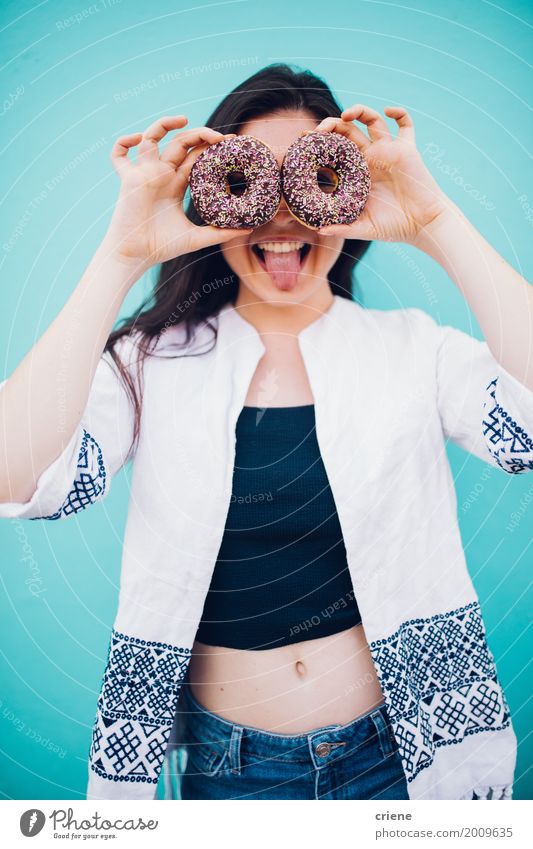 Junge Frau, die das lustige Gesicht hält Schaumgummiringe in den Händen zieht Lebensmittel Kuchen Dessert Süßwaren Schokolade Essen Lifestyle Freude feminin