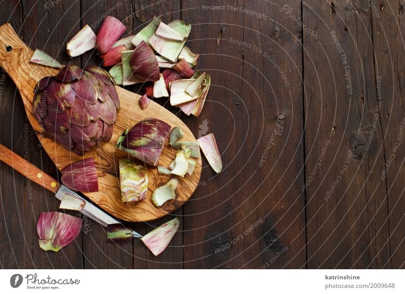 Römische Artischocken auf einem Holzbrett mit Messer Gemüse Ernährung Vegetarische Ernährung frisch grau grün Ackerbau purpur Essen zubereiten geschnitten