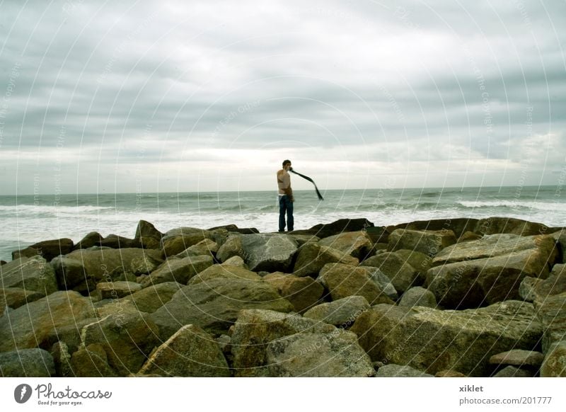 Junge am Strand 1 Mensch Wolken Herbst Wind Felsen Wellen Meer Denken Blick frisch kalt natürlich positiv wild Gelassenheit ruhig Einsamkeit Freude Farbfoto