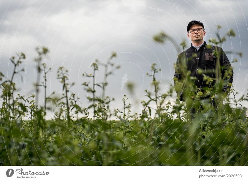 Bewölkt und Mann im Unkraut 1 Wolken graue Wolken schlechtes Wetter Feld grün Pflanze Junger Mann verloren stehen warten Waldmensch verirrt irre Landwirt