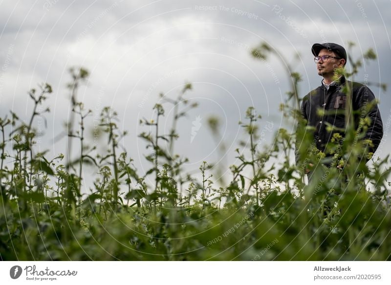 Bewölkt und Mann im Unkraut 2 Wolken graue Wolken schlechtes Wetter Feld grün Pflanze Junger Mann verloren stehen warten Waldmensch verirrt irre Landwirt