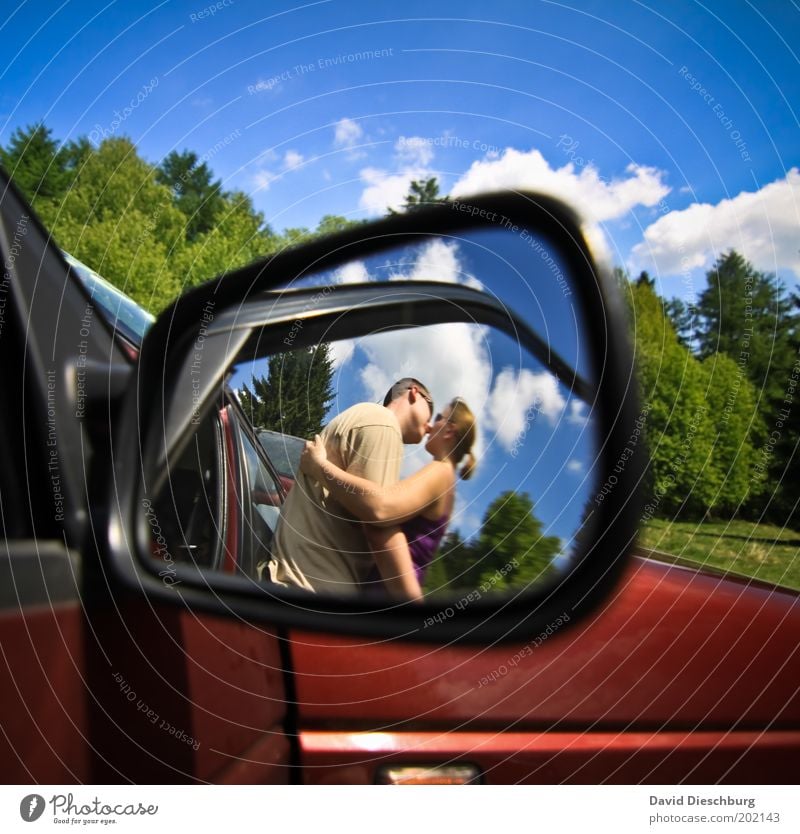 Liebe auf dem Parkplatz Mensch Junge Frau Jugendliche Junger Mann Paar Partner 2 18-30 Jahre Erwachsene Wolken Frühling Sommer Schönes Wetter PKW blau Küssen