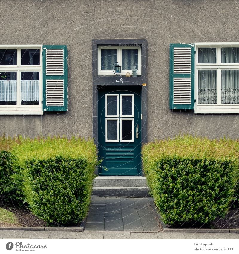 Im Wunderland #5 Haus Einfamilienhaus Treppe Fassade Fenster Tür trist Architektur Hecke Fensterladen Gardine Hausnummer Häusliches Leben Heimat Eingang