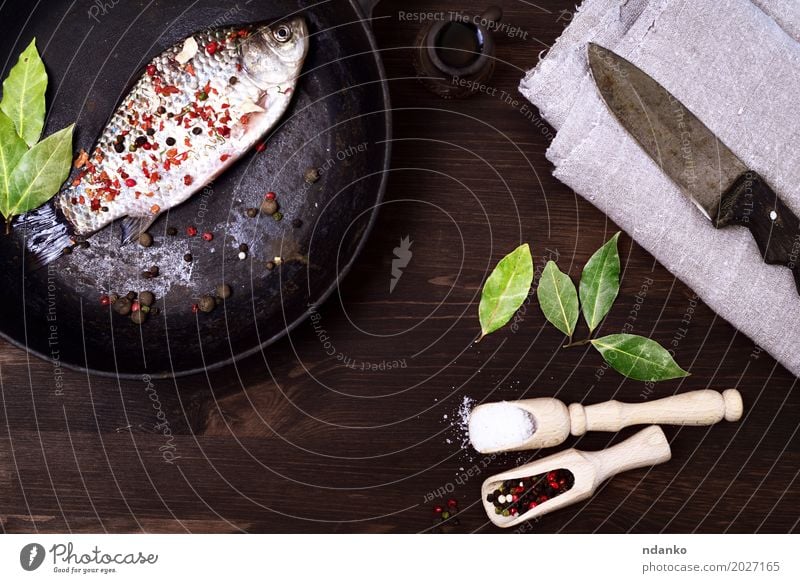 Fisch crucian in einer Gusseisenbratpfanne mit Gewürzen Kräuter & Gewürze Ernährung Pfanne Löffel Tisch Küche Essen frisch lecker retro braun schwarz Kruzianer