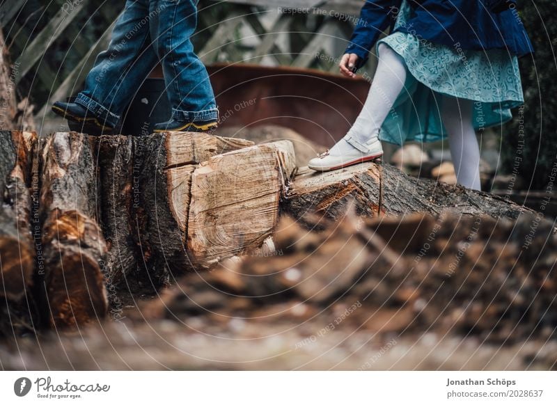 Kinder spielen auf Holzstämmen Spielplatz Spielen Abenteuer Abenteurer aufregend Baumstamm Natur treten Beine Wald Garten Junge Außenaufnahme Mensch braun