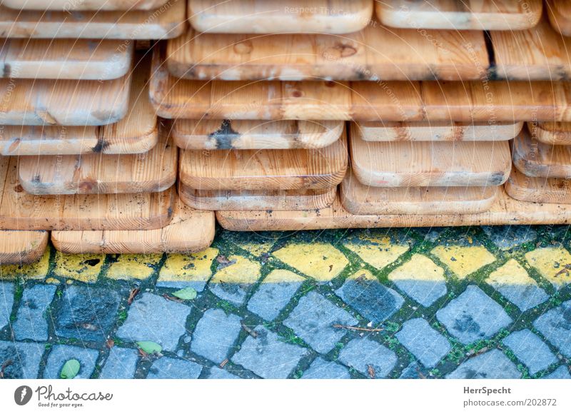 Depot braun gelb grau Pflastersteine Linie Bierbank Biertische Stapel Holz Farbfoto Gedeckte Farben Außenaufnahme Nahaufnahme Detailaufnahme Textfreiraum unten