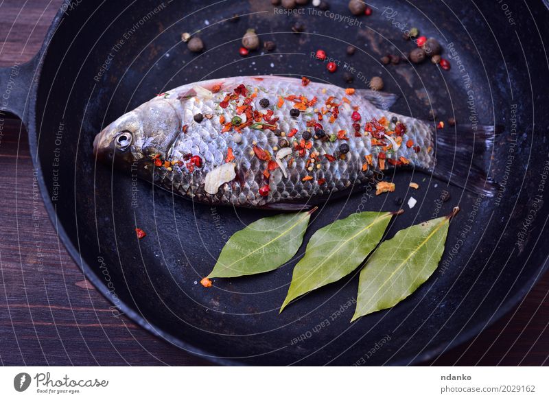 Karpfen mit Gewürzen in einer schwarzen Gusseisenpfanne Fisch Kräuter & Gewürze Pfanne Tisch Küche Natur Blatt Holz Essen frisch oben braun grün Kruzianer