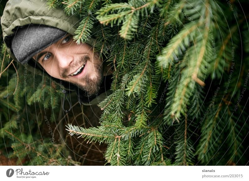 lunschen maskulin Mann Erwachsene Leben Kopf Tanne entdecken Freude verstecken Versteck hervorrufen dumm bescheuert grün Tarnung Tarnfarbe Kapuze lachen Lächeln