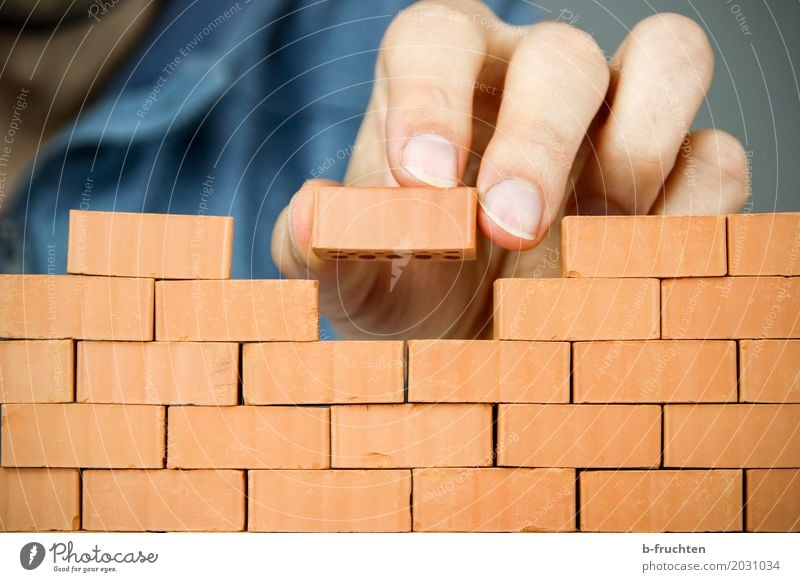 Stein auf Stein ... Handwerker Mann Erwachsene Finger 30-45 Jahre Haus Mauer Wand Backstein rot Freude Genauigkeit Zukunft bauen Spielstein Spielen