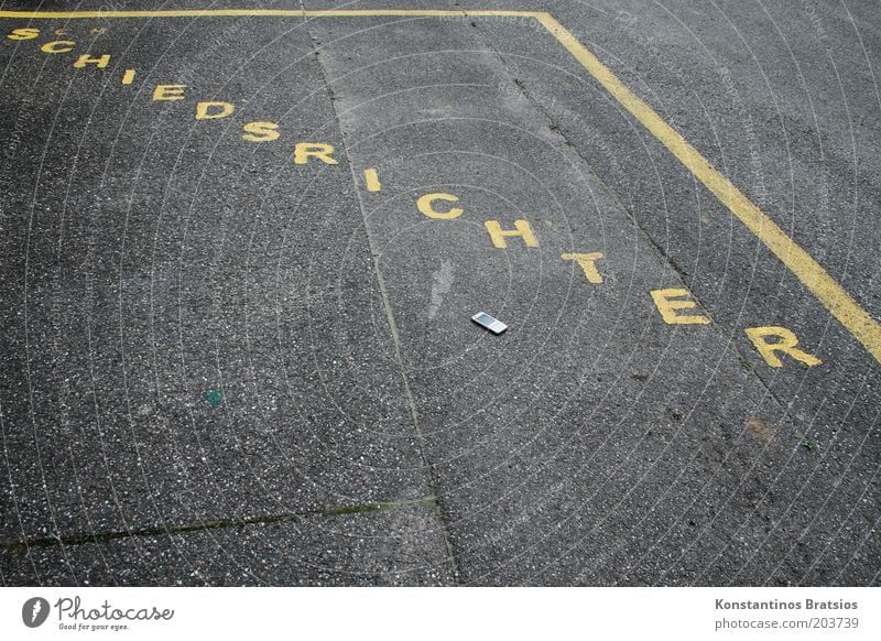 Schiri Telefon Sport Ballsport Schiedsrichter Sportstätten Fußballplatz Schriftzeichen groß unten gelb Perspektive Parkplatz Straßenbelag Asphalt anthrazit Wort