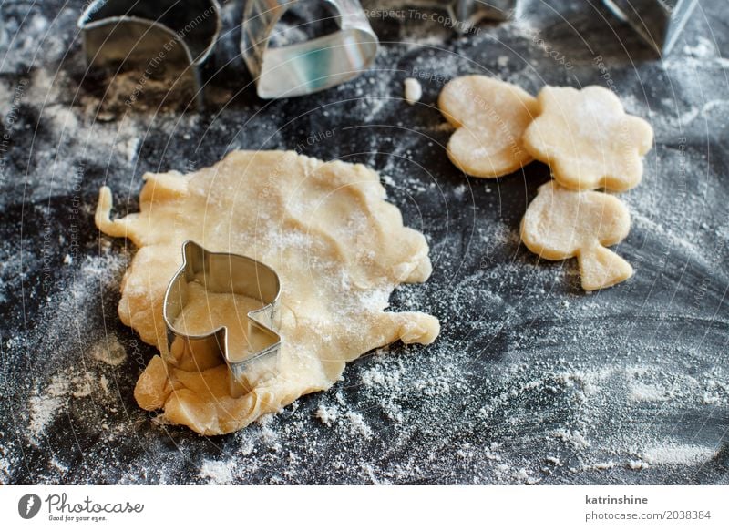 Schließen Sie oben von den Plätzchenschneidern in einem Teig auf einer dunklen Tabelle Teigwaren Backwaren Dessert Küche Herz machen backen Bäckerei Biskuit