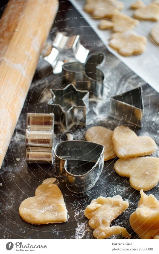 Schließen Sie oben von den Plätzchenschneidern und Nudelholz auf einer dunklen Tabelle Teigwaren Backwaren Dessert Küche Herz machen backen Bäckerei Biskuit