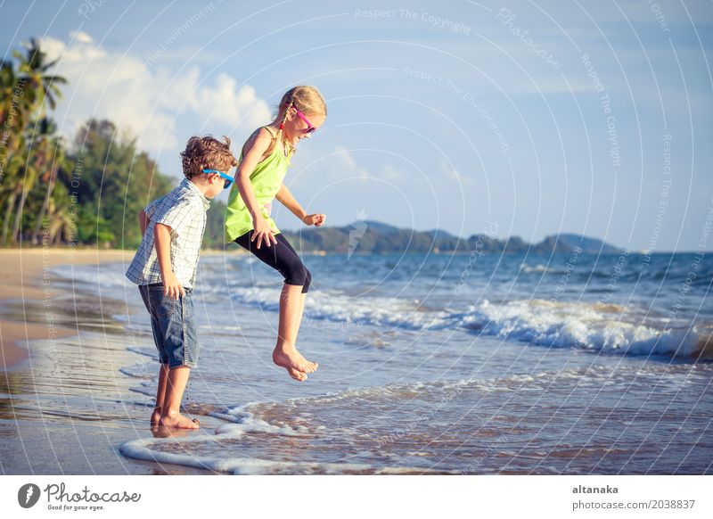 Glückliche Kinder, die auf dem Strand zur Tageszeit spielen. Lifestyle Freude Erholung Freizeit & Hobby Spielen Ferien & Urlaub & Reisen Abenteuer Freiheit