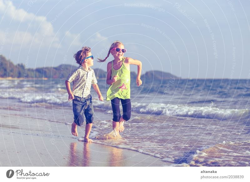 Glückliche Kinder, die auf dem Strand zur Tageszeit spielen. Lifestyle Freude Erholung Freizeit & Hobby Spielen Ferien & Urlaub & Reisen Abenteuer Freiheit