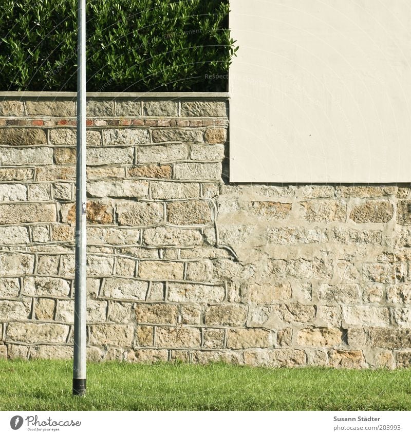 Platz für ein Stückchen Grün Mauer Wand Fassade eckig Sandstein verputzt Laterne Laternenpfahl Sträucher Hecke Begrenzung Gras mehrfarbig Außenaufnahme