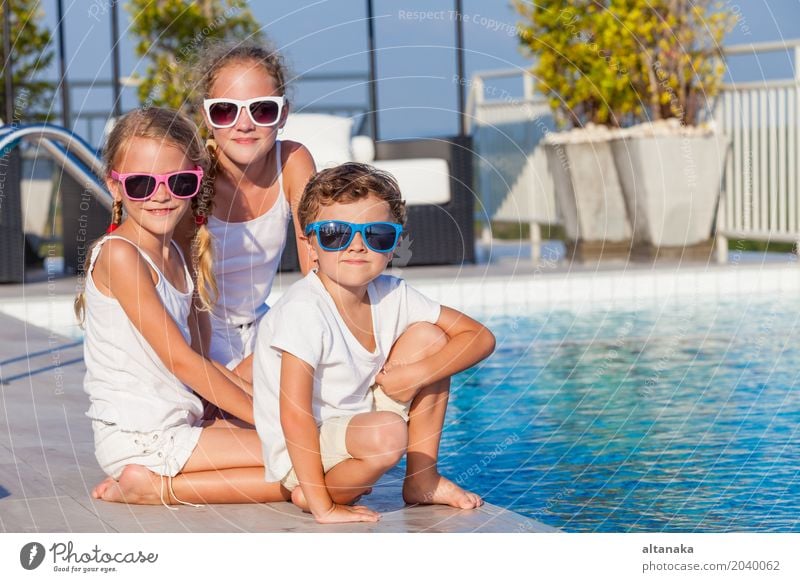 glückliche Kinder, die nahe dem Swimmingpool spielen Lifestyle Freude Glück Gesicht Erholung Schwimmbad Freizeit & Hobby Spielen Ferien & Urlaub & Reisen Sommer