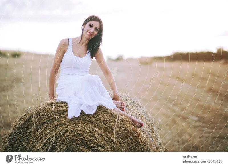 Lächelndes Mädchen, das auf dem Stroh sitzt Lifestyle elegant Stil Mensch feminin Junge Frau Jugendliche Erwachsene 1 30-45 Jahre Landschaft Wiese Feld Mode