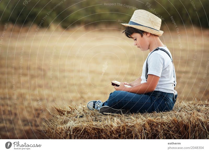 Junge liest ein Buch auf dem Feld Lifestyle Freizeit & Hobby Kindererziehung Bildung lernen Mensch Kleinkind Kindheit 1 3-8 Jahre Natur Landschaft Wiese