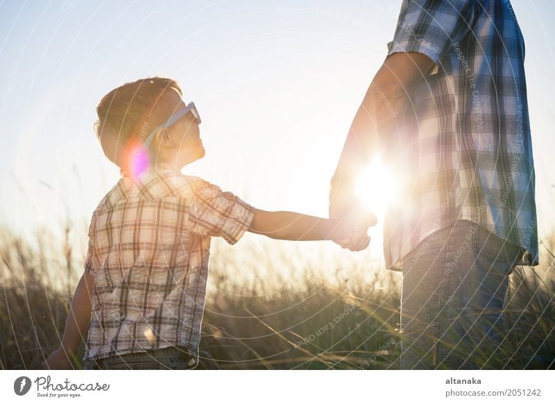 Vater und Sohn, die auf dem Feld zur Tageszeit spielen. Lifestyle Freude Leben Erholung Freizeit & Hobby Spielen Ferien & Urlaub & Reisen Ausflug Abenteuer