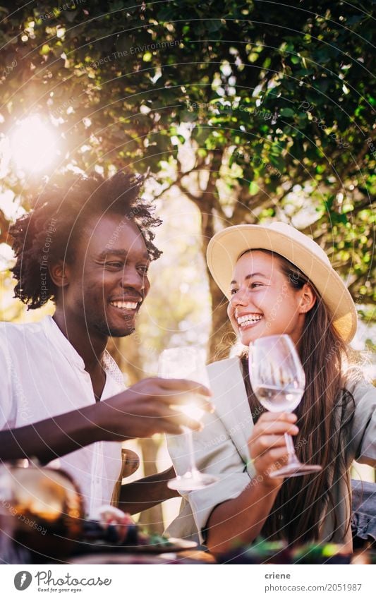 Süßes gemischtes Rassenpaar, das am Abend gemeinsam Wein genießt. Mittagessen Getränk trinken Erfrischungsgetränk Alkohol Glas Freude Sommer Restaurant ausgehen