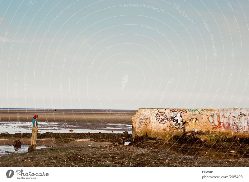 ausblick Mensch 1 Küste Strand Meer Mauer Wand Graffiti Blick stehen träumen Traurigkeit kaputt trist Vergänglichkeit Wattenmeer Ebbe nachdenklich Farbfoto