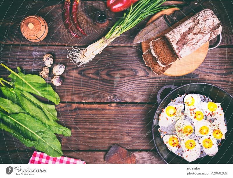 Gebratene Wachteleier Brot Kräuter & Gewürze Frühstück Mittagessen Abendessen Pfanne Messer Küche Restaurant Holz Essen frisch oben braun grün Tradition Zwiebel