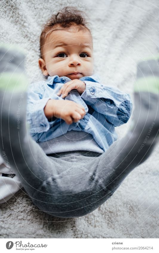 Netter Kleinkindjunge, der auf das Bett betrachtet Kamera legt Lifestyle Freude Leben Wohlgefühl Häusliches Leben Kinderzimmer Schlafzimmer maskulin Baby Junge