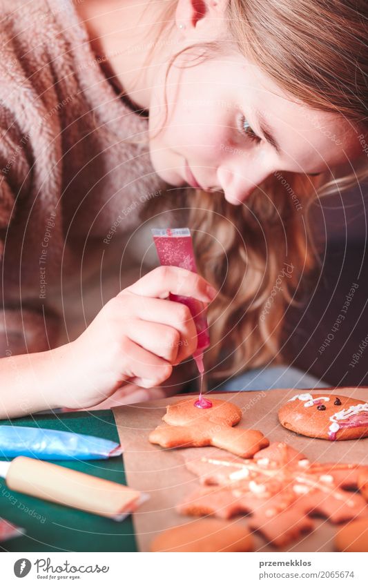 Mädchen, das Weihnachtslebkuchenplätzchen mit dem Zuckerguss verziert Lifestyle Dekoration & Verzierung Tisch Feste & Feiern Weihnachten & Advent Mensch 1