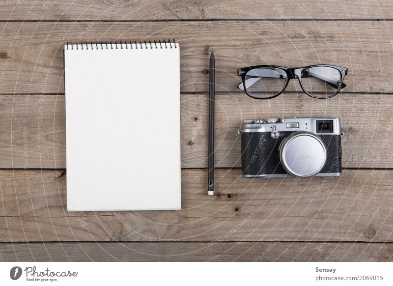 Notizblock, Gläser und Kamera auf dem hölzernen Schreibtisch Ferien & Urlaub & Reisen Tisch Arbeitsplatz Büro Business Fotokamera Musiknoten Papier Schreibstift