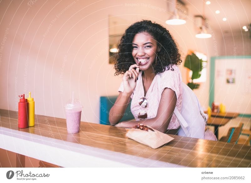 Junge afrikanische Frau, die Kartoffelfischrogen im Restaurant isst Lebensmittel Essen Mittagessen Abendessen Fastfood Lifestyle Freude Freizeit & Hobby Mensch