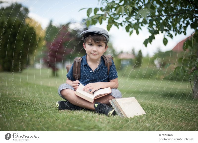 Schulanfang Mensch Kind Junge Kindheit Leben 1 3-8 Jahre Lächeln lernen sitzen brünett lesen Schule Einschulung Schulranzen antik Buch aufgeschlagen Farbfoto