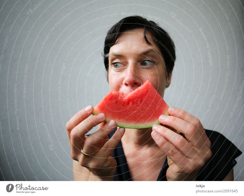 Not so young but happy Caucasian woman chewing watermelon Frucht Melonen Wassermelone Ernährung Essen Bioprodukte Vegetarische Ernährung Fingerfood Lifestyle