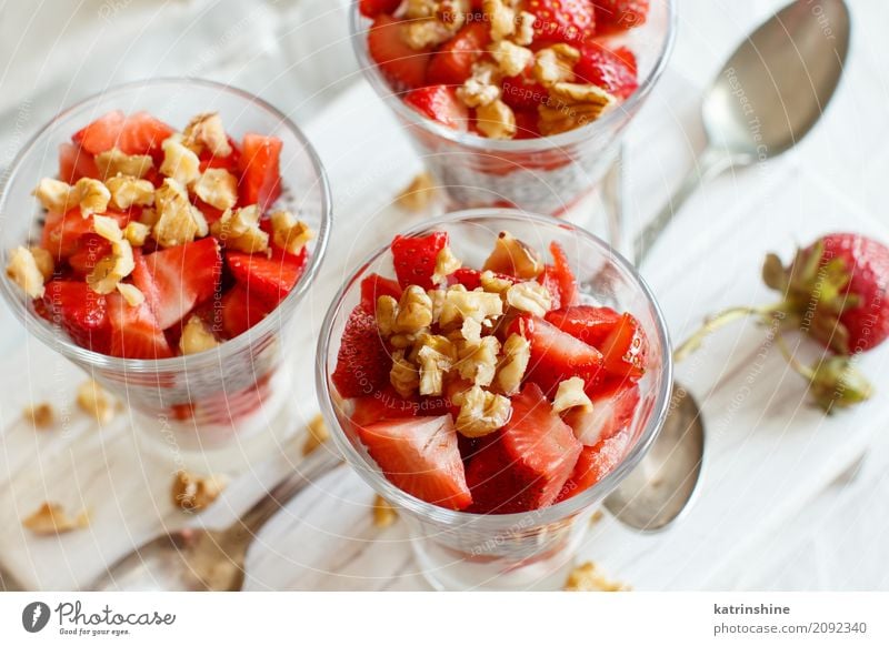 Chia Pudding Erdbeerparfait mit griechischem Joghurt und Nüssen Frucht Dessert Essen Frühstück Diät Glas Löffel rot weiß Beeren Müsli Samen Molkerei