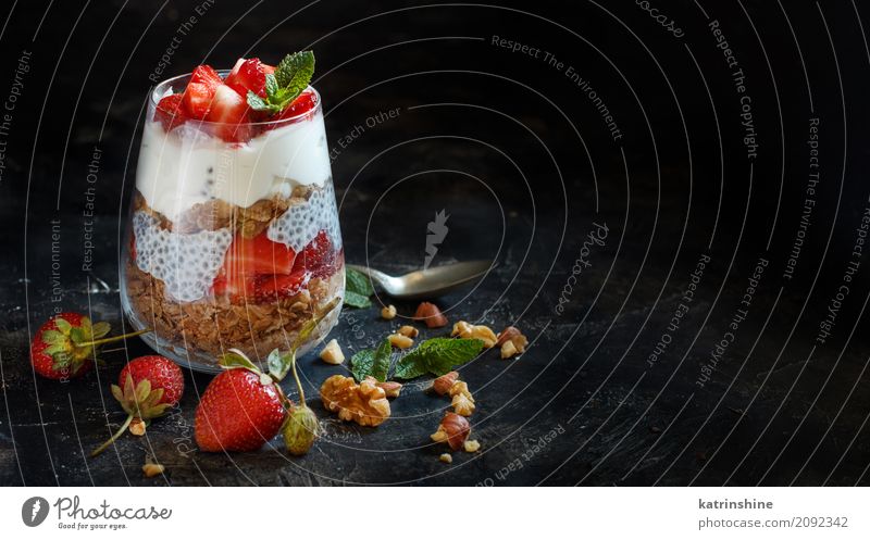 Chia Pudding Erdbeerparfait mit griechischem Joghurt und Nüssen Frucht Dessert Frühstück Diät Glas Löffel dunkel rot weiß Beeren Müsli Samen Molkerei