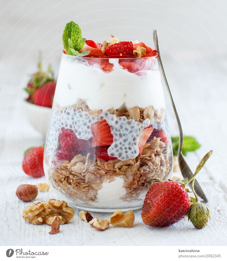 Chia Pudding Erdbeerparfait mit griechischem Joghurt und Nüssen Frucht Dessert Frühstück Diät Glas Löffel grün rot weiß Beeren Müsli Samen Molkerei