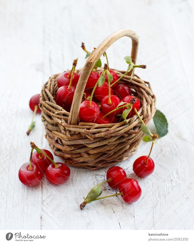 Frischer Sauerkirschen ina Korb auf einem Holztisch Frucht Vegetarische Ernährung Diät Sommer Tisch Blatt dunkel frisch lecker saftig sauer wild braun grün rot