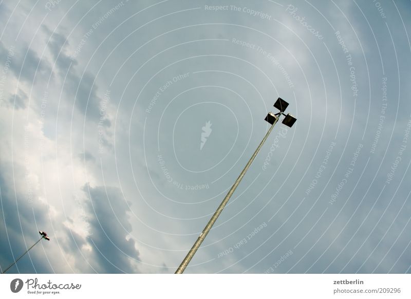 Zwei Laternen Himmel Wolken Wetter schlechtes Wetter Licht Beleuchtung Parkplatz Parkplatzbeleuchtung Flutlicht Farbfoto Außenaufnahme Menschenleer