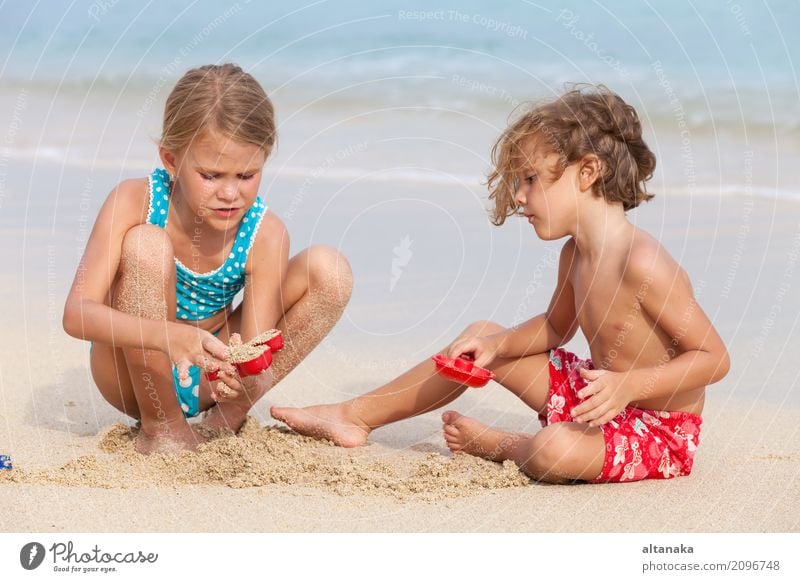 Zwei glückliche Kinder, die auf dem Strand spielen Lifestyle Freude Glück schön Erholung Freizeit & Hobby Spielen Ferien & Urlaub & Reisen Freiheit Sommer Sonne