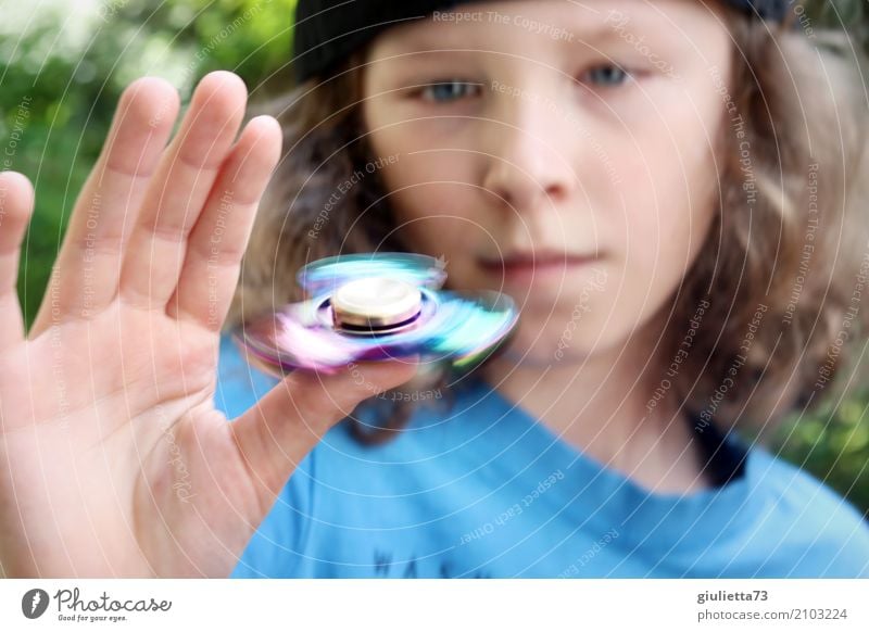 Tempo | Fidget Spinner Hype || Kind Junge Hand Finger 1 Mensch 8-13 Jahre Kindheit Mütze langhaarig Locken Bewegung drehen Erholung Coolness glänzend trendy