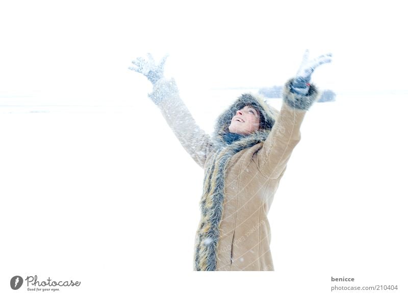 es wintert Frau Mensch Schnee Schneefall Winter lachen Lächeln Freude Mantel Wintermantel Kapuze schön Natur attraktiv kalt Arme Hand hoch oben Blick