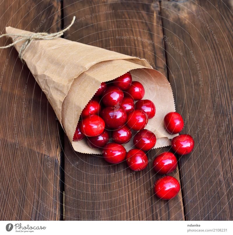 Reife rote Kirsche in einer Papiertüte Frucht Dessert Essen Vegetarische Ernährung Saft Sommer Tisch Natur Holz frisch natürlich oben retro saftig Hintergrund