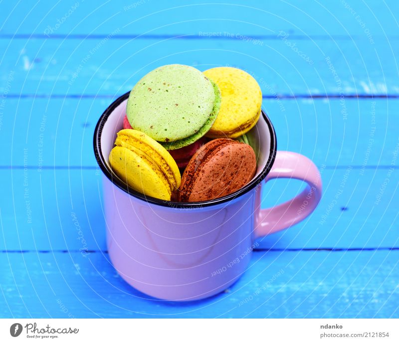 Mandel Keks Macaron in einem Becher Dessert Süßwaren Tasse Tisch Gastronomie Holz hell lecker oben blau braun gelb grün rosa Tradition farbenfroh Hintergrund