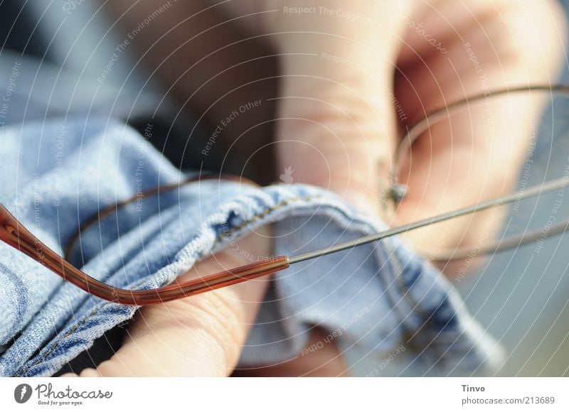 Für Durchblick sorgen. Finger Reinigen blau Brille Optisches Gerät Jeansstoff haltend Vorsicht Glas dreckig Brillenputztuch Linse Farbfoto Außenaufnahme Mensch