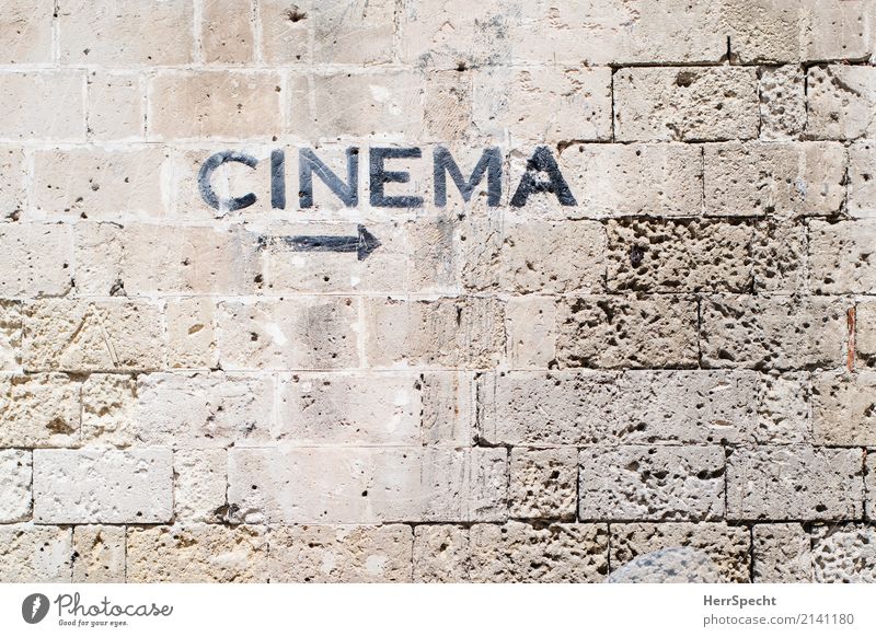 Movies to the right Mauer Wand Stein Hinweisschild Warnschild Pfeil alt ästhetisch braun Kino Filmindustrie Kinosaal Hinweispfeil cinema Steinmauer Farbfoto