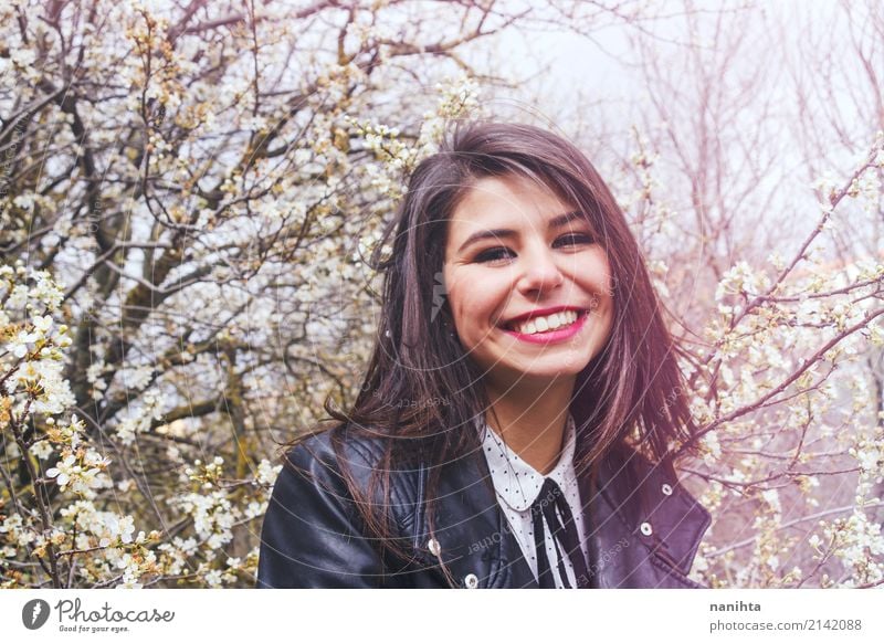 Junge Frau, die am Frühjahr lächelt Lifestyle Stil Freude schön Mensch feminin Jugendliche 1 18-30 Jahre Erwachsene Natur Frühling Baum Blume Garten Park Mode