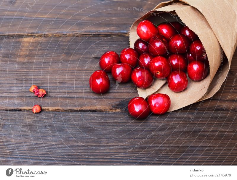 rote Kirsche in einer Papiertüte Frucht Dessert Essen Vegetarische Ernährung Saft Sommer Garten Tisch Natur Holz frisch natürlich oben saftig Hintergrund Beeren