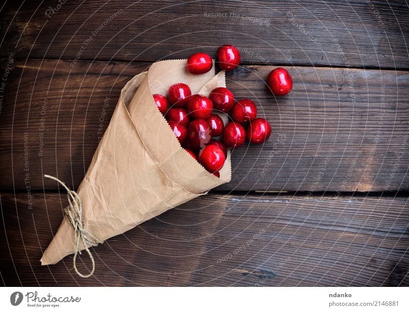 Reife rote Kirsche in einer Papiertüte Frucht Dessert Essen Vegetarische Ernährung Saft Sommer Garten Tisch Natur Holz frisch natürlich oben saftig Hintergrund