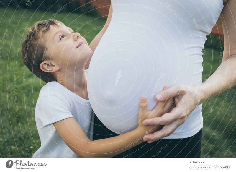 Glücklicher kleiner Junge, der seine Mutter tagsüber im Park umarmt. Sie haben Spaß in der Natur. Konzept des Glücks. Lifestyle Freude Freizeit & Hobby