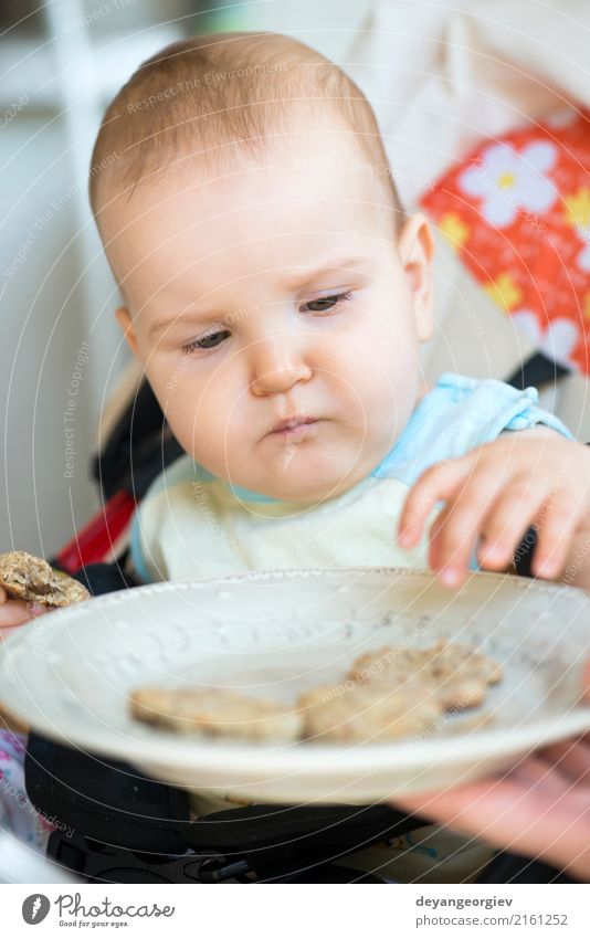 Baby isst alleine. Essen Frühstück Mittagessen Löffel Stuhl Tisch Kind Kleinkind klein niedlich Appetit & Hunger Einsamkeit Kekse Speise Lebensmittel Mädchen