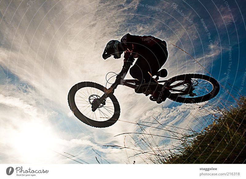 Mountainbikeski II Sport Fahrradfahren 1 Mensch Bewegung Coolness springen Gedeckte Farben Außenaufnahme Tag Froschperspektive Helm Himmel Wolken Gras fliegen